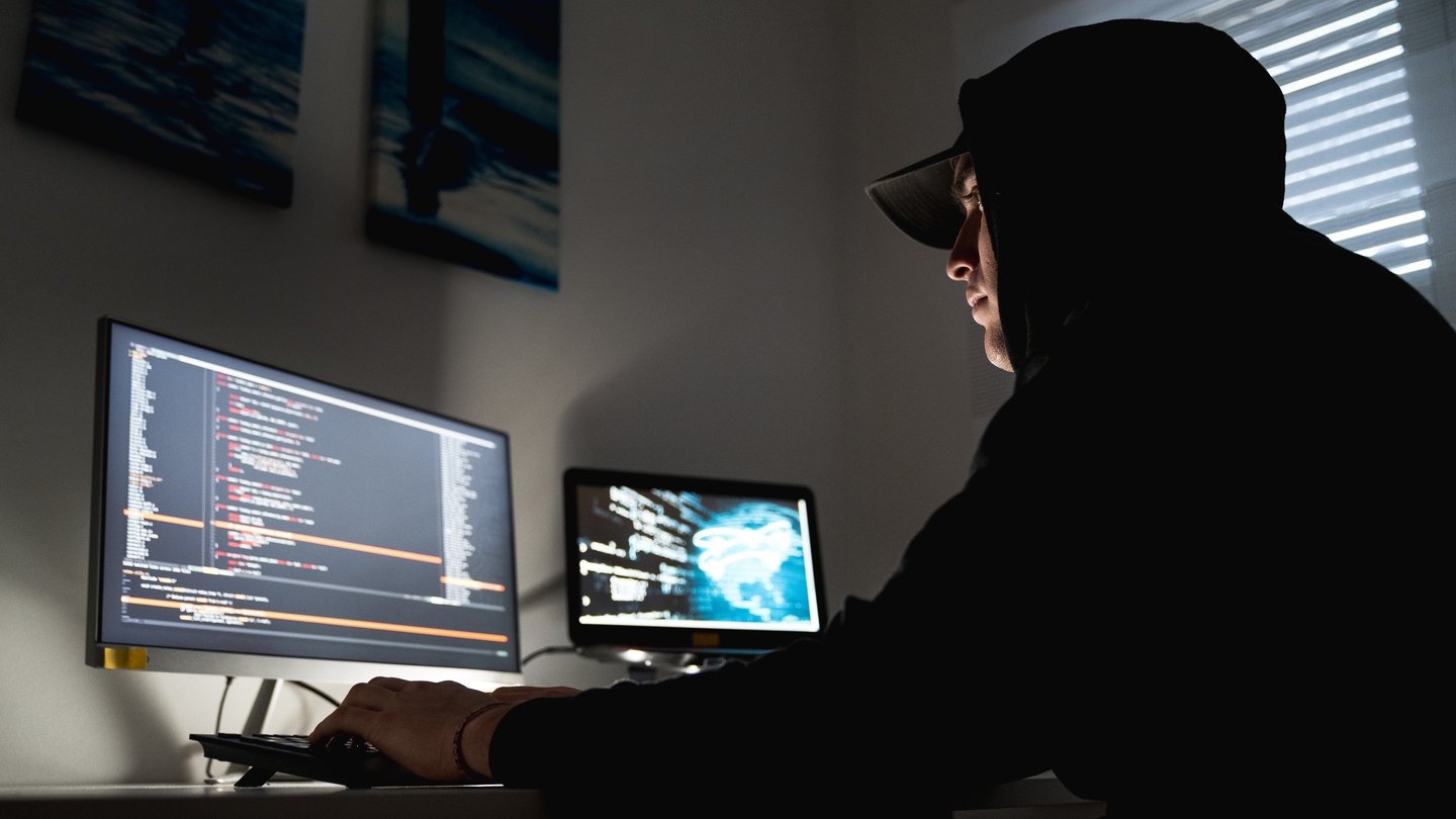 Person in hoodie hacking cyber security courses